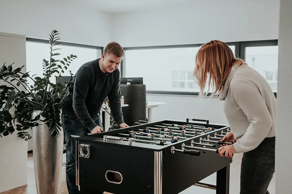 Unsere Mitarbeiter beim Tischkicker spielen im Unternehmen